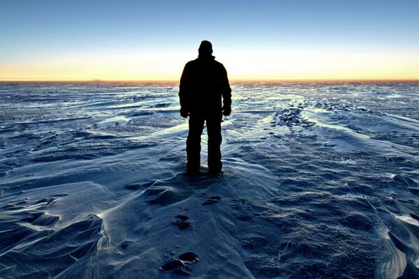 Un hombre admira la puesta de sol en la Antártida