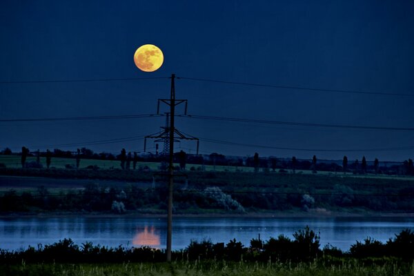 Un paisaje místico con una Luna que se refleja en el agua