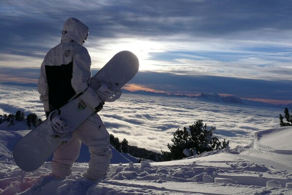 Snowboarder on a mountainside against a beautiful sky