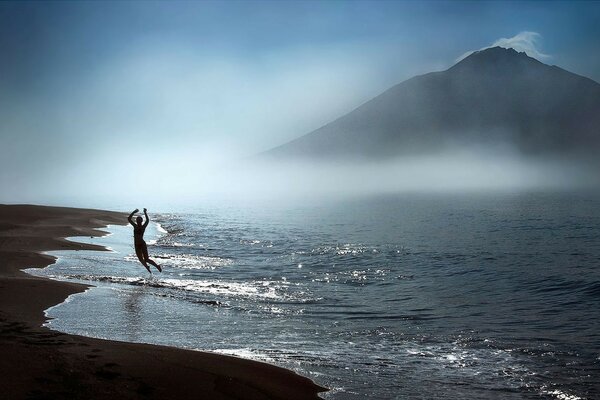 A man on the seashore against the background of rocks