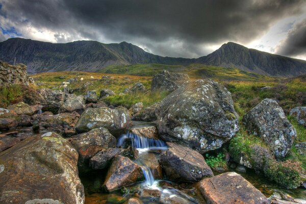 Mountain river on the background of mountains and dark sky