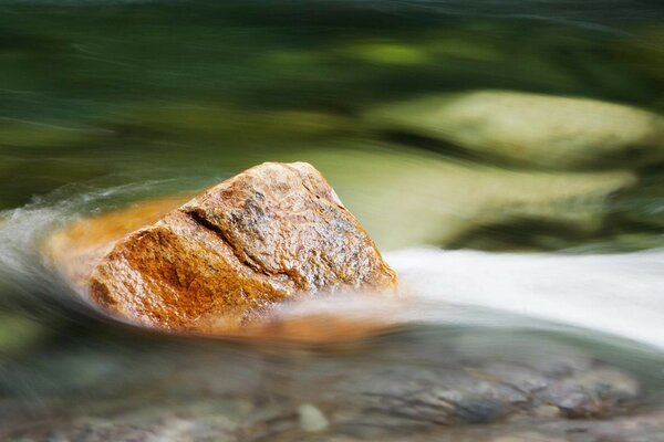 Gran piedra en el agua contra el flujo