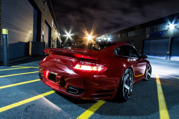 A red porsche 997tt car, the bumper almost touches the asphalt