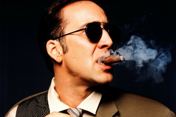 Nicolas Cage smokes a cigar