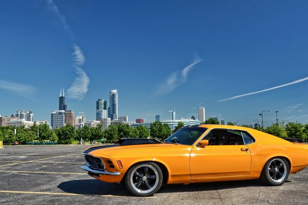 Ford Mustang amarillo en el fondo de la ciudad