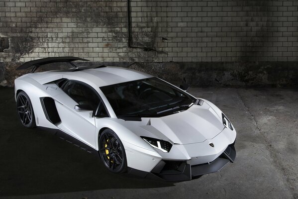 Weißes Lamborghini-Auto auf Backsteinmauer-Hintergrund