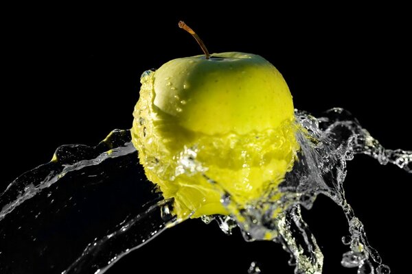 Yellow apple in a splash of water