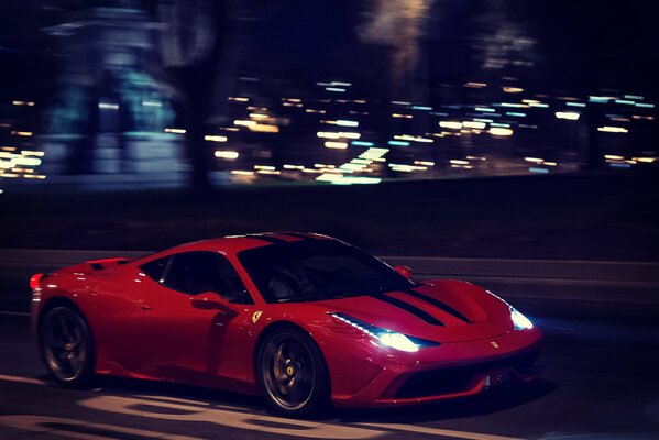 Ferrari rojo en la noche conduce por la pista