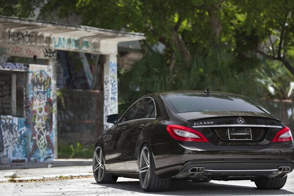 Mercedes noire sur fond de bâtiment peint graphiti