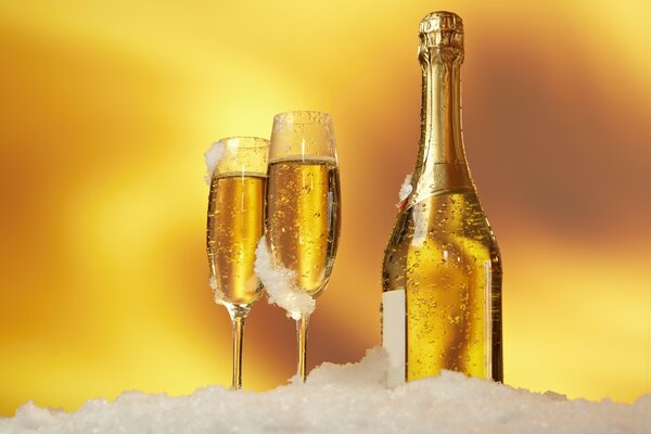 Bottiglia di champagne e bicchieri di vino nella neve