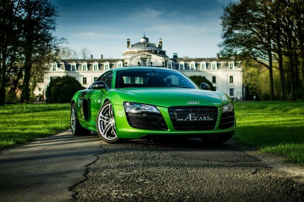 Green new Audi on the background of a new house