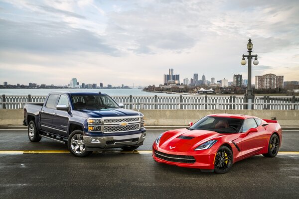 Chevrolet Silverado negro y Chevrolet Corvette rojo en el paseo marítimo