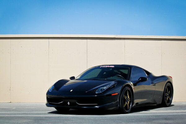 Ferrari negro en el estacionamiento contra la pared