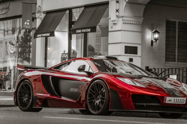 A red car on the background of a gray building