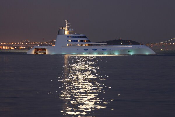 Yacht im Meer vor dem Hintergrund der Brücke und der Lichter in der Nacht