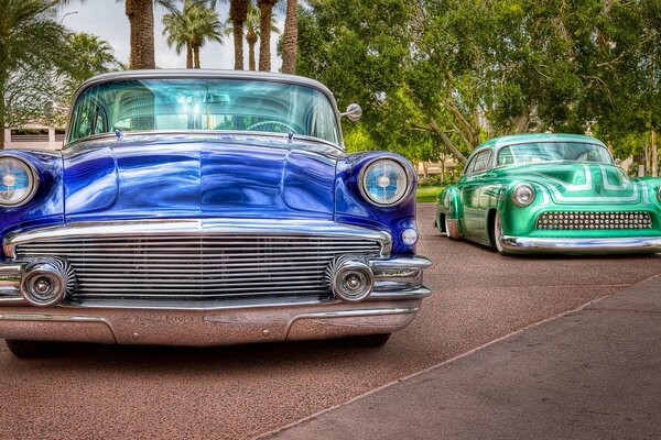 Two Buicks on a background of palm trees