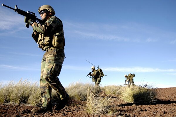 Soodates dans le désert avec des armes