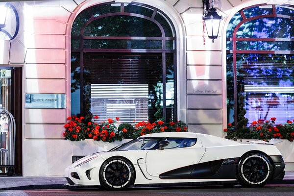 Voiture de sport sur fond de bâtiment avec des fleurs