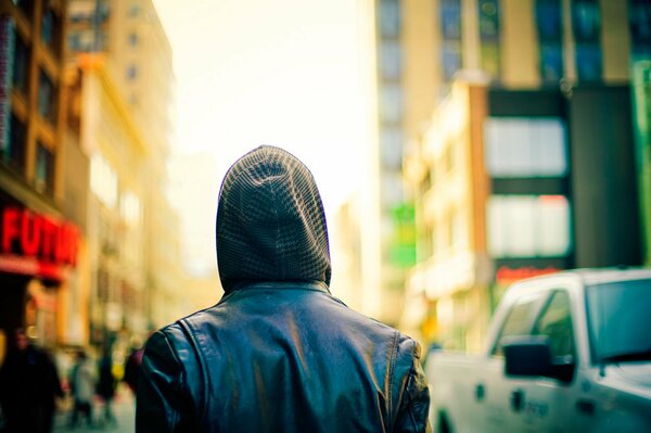 Un passant à capuche dans une grande ville