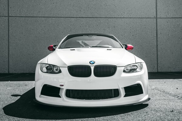 WEIßER BMW M3 AUF WANDHINTERGRUND