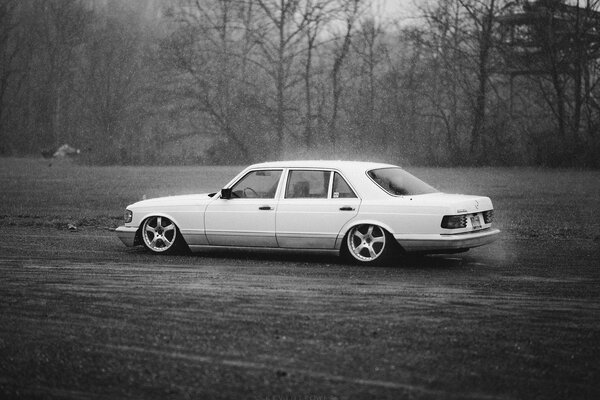 Mercedes blanco en la carretera en tiempo de lluvia