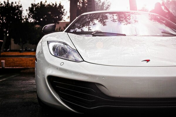 White McLaren supercar in the rain