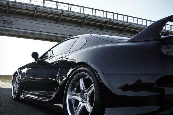 The black Toyota is ready to start under the bridge