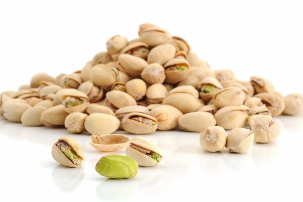 Lots of delicious pistachios on a white background