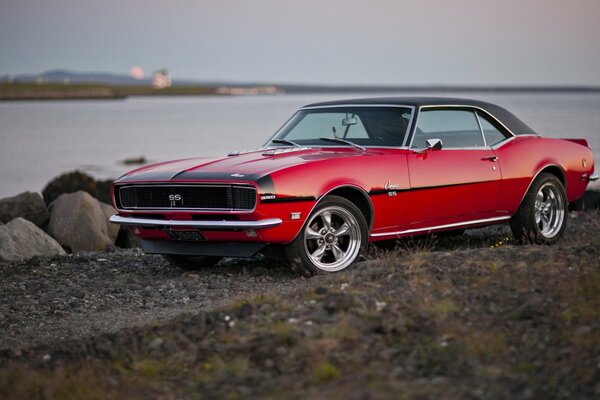 Red Chevrolet Camaro 1968 on the background of the river