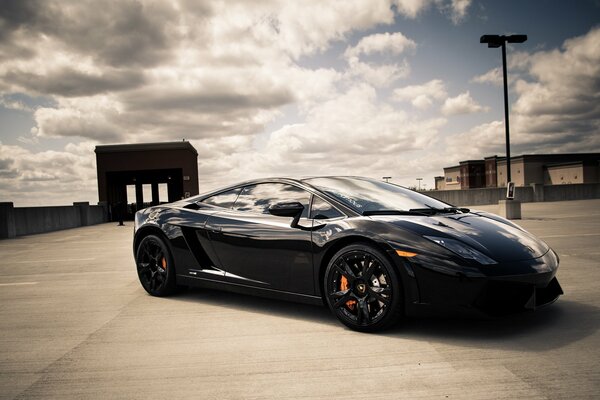 Lamborghini negro en el fondo de las nubes flotantes