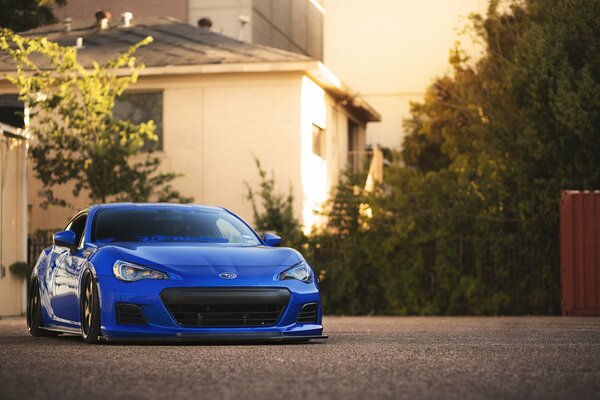 Blue subaru on the background of houses