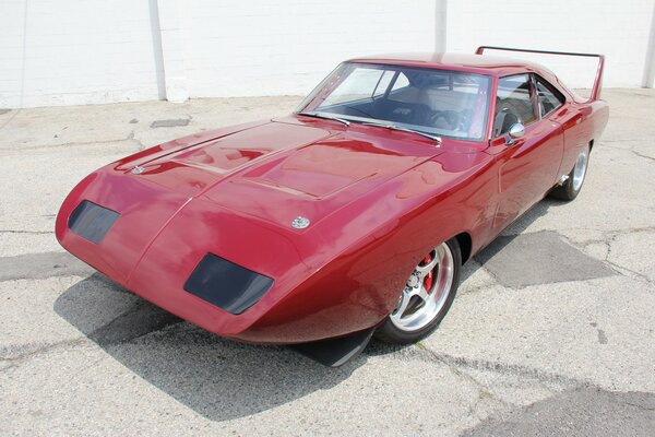 The red challenger is standing on the asphalt