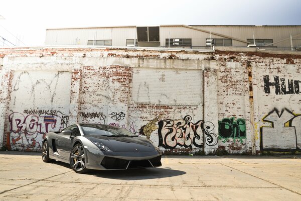 Lamborghini na tle ceglanego muru z graffiti