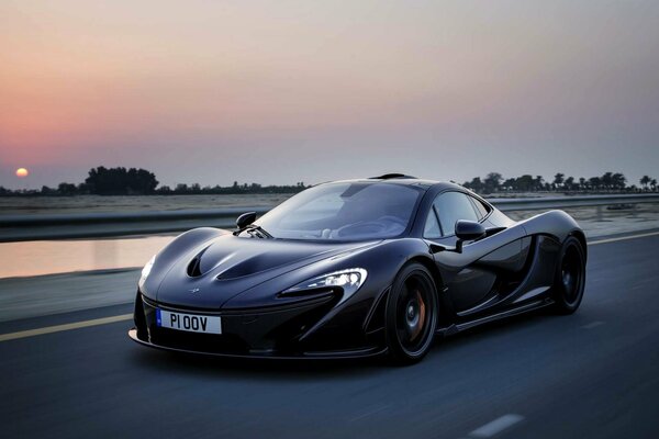 Black McLaren supercar before evening sunset