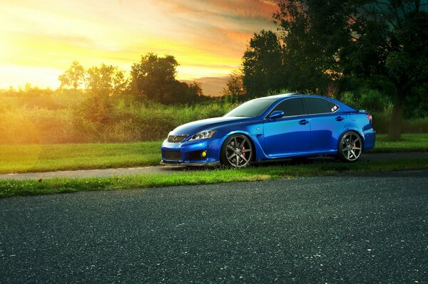 Blue Lexus in nature with a bright sun