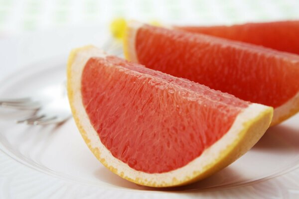 Grapefruitscheiben auf einem Teller auf weißem Hintergrund