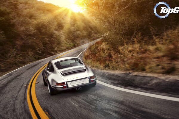 Ford white rides on a country highway against the background of sunset