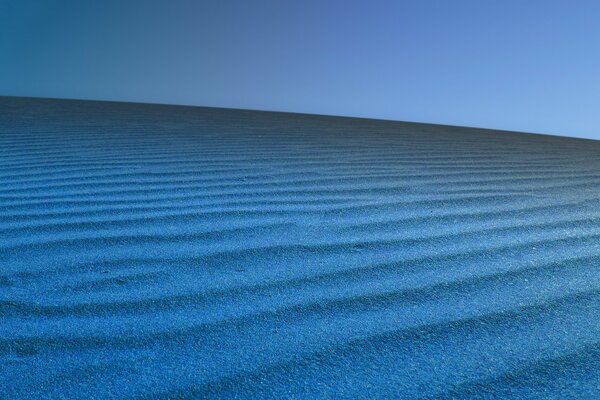 Dunes with blue sand on a blue background