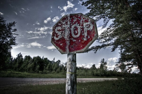 The old shot stop sign on the background of the forest