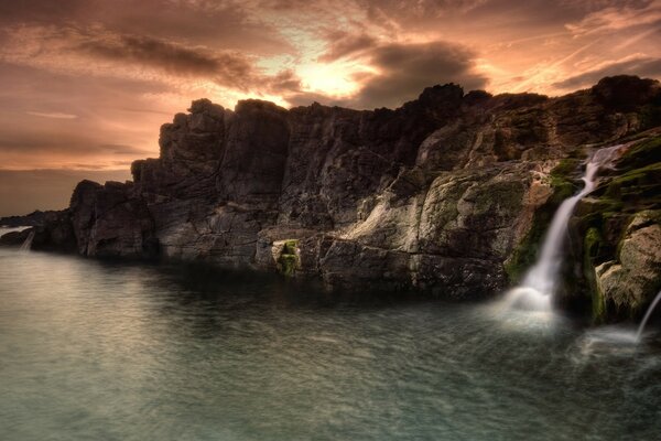 Cascada entre las rocas al atardecer