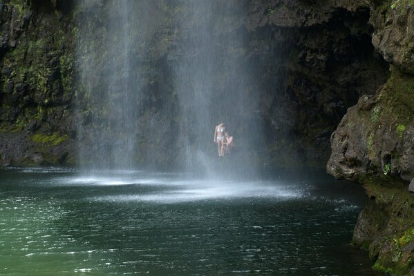 A couple of people are sitting on a waterfall