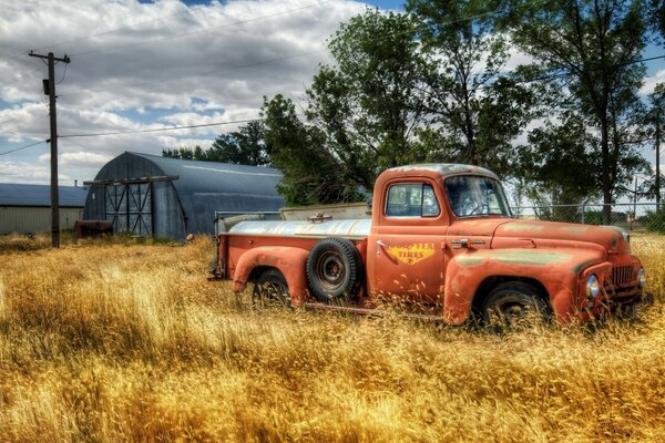 A truck near the hangar and a circle of yellow grass