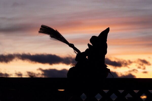 Figurine de sorcière sur un balai sur fond de ciel