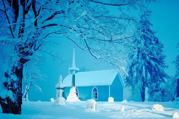 Árboles de Navidad y la iglesia en medio de la nieve