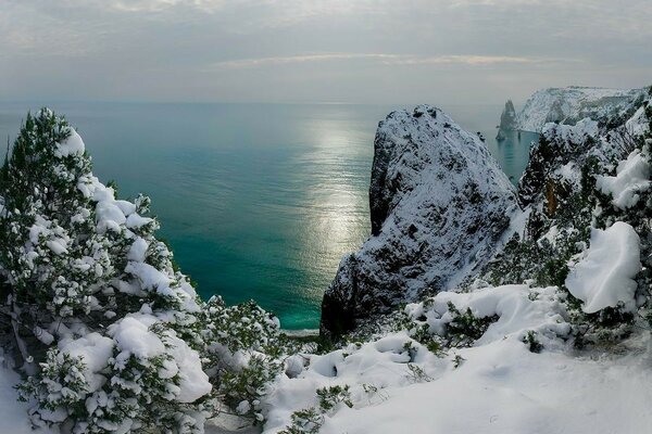 Заснеженные зимние скалы у чёрного моря в Крыму