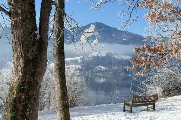 Banc solitaire enneigé près du lac