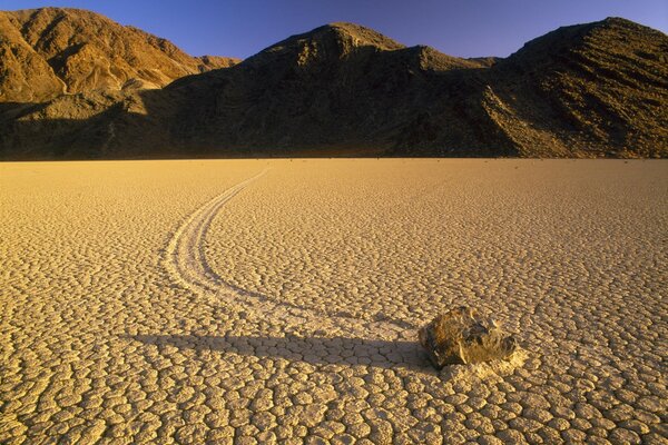 A stone in the desert against the background of mountains