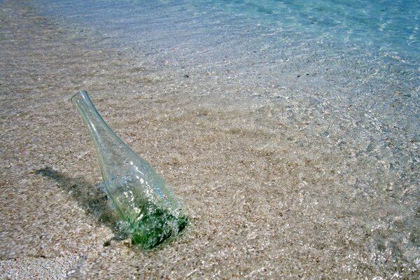 Botella de tiro en la orilla del mar