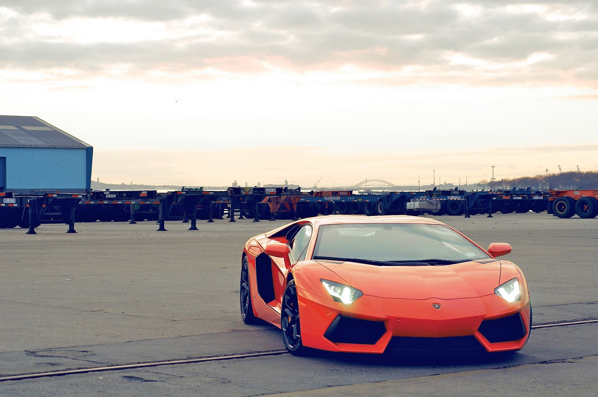 lamborghini aventador lp700-4 pomarańczowy lamborghini aventador widok z przodu światło reflektorów niebo chmury budynek