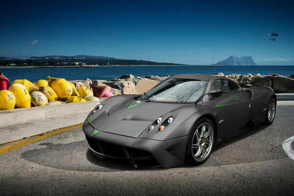 Coche deportivo gris de Pagani waira en el paseo marítimo